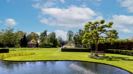 Groene tuin met zwemvijver aan klassieke villa