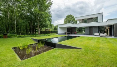 Achtertuin modern wit huis met zwemvijver