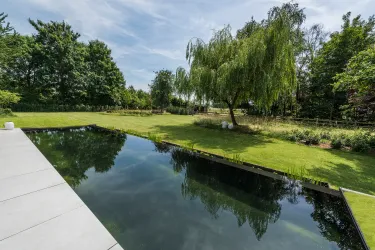 Villatuin met overloop zwemvijver in groene omgeving